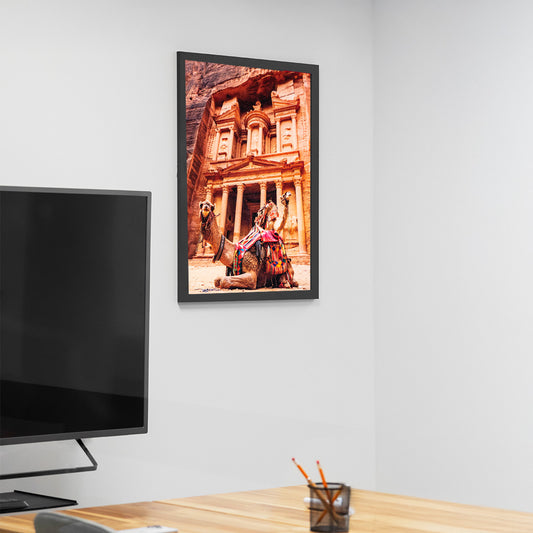 Framed artwork of a historical building on a wall above a desk with a TV.