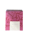 Pink notebook with Arabic calligraphy design on a white background